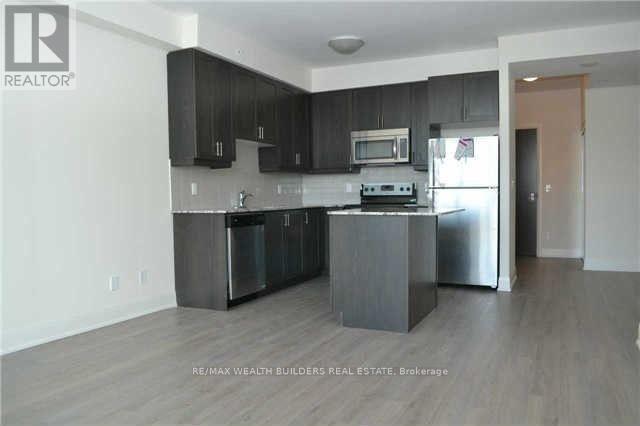 A kitchen with black cabinets and stainless steel appliances.