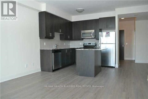 A kitchen with black cabinets and stainless steel appliances.
