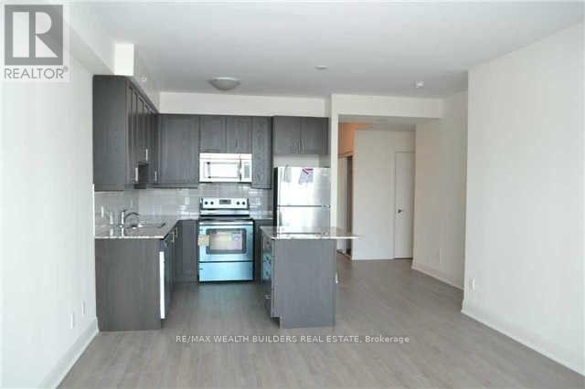 A kitchen with a stove top oven and a refrigerator.