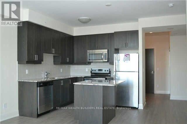 A modern kitchen with dark wood cabinets and stainless steel appliances.