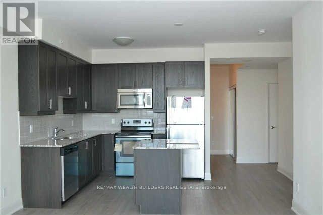 A kitchen with dark wood cabinets and stainless steel appliances.