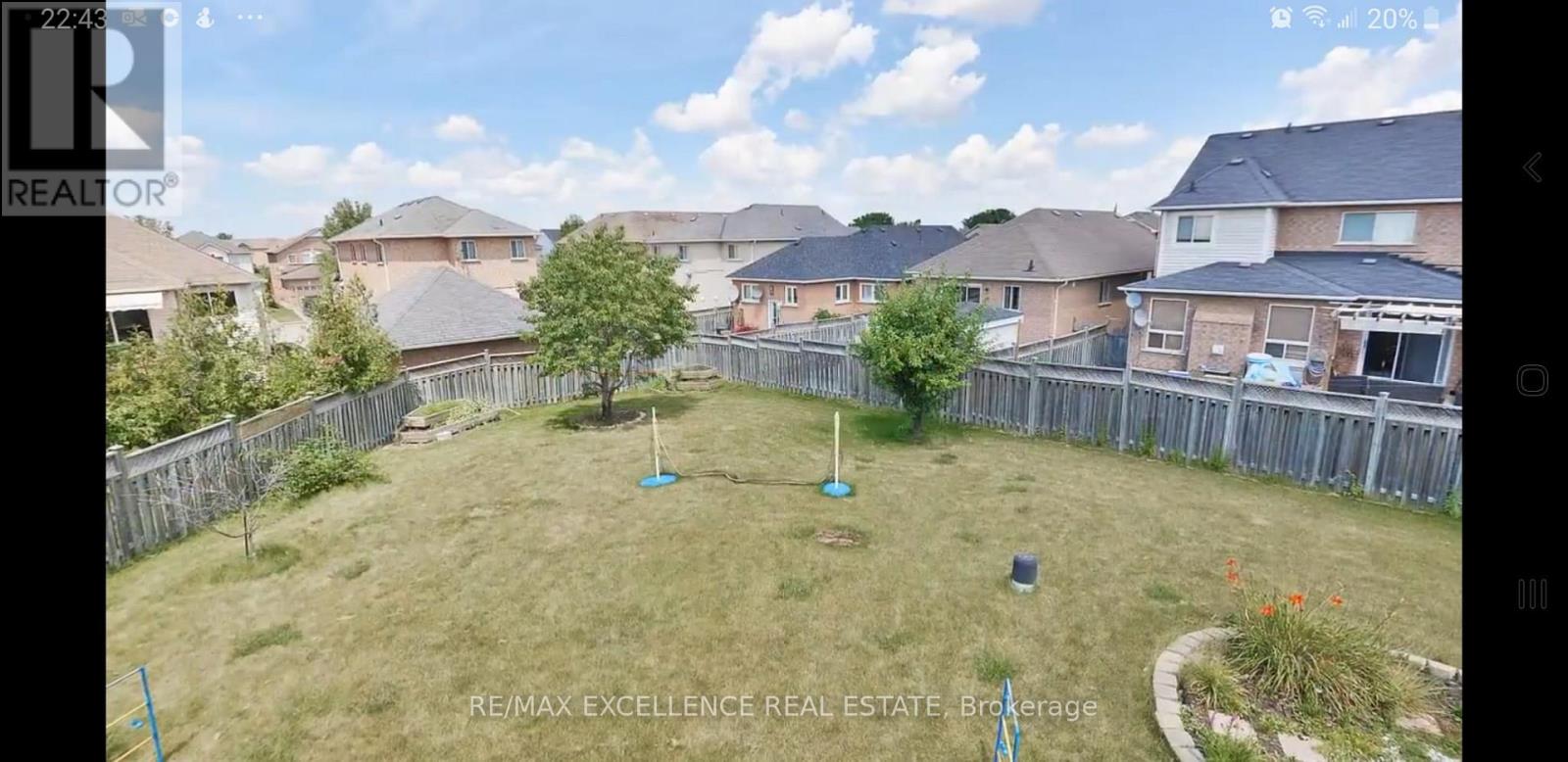 A backyard with a tree and a blue object on the grass.