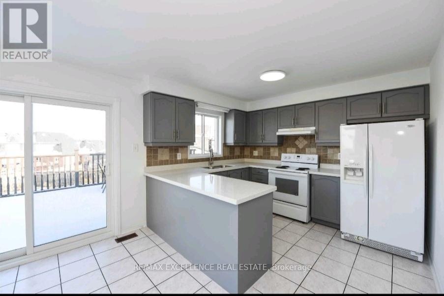A kitchen with a white fridge and a white island.