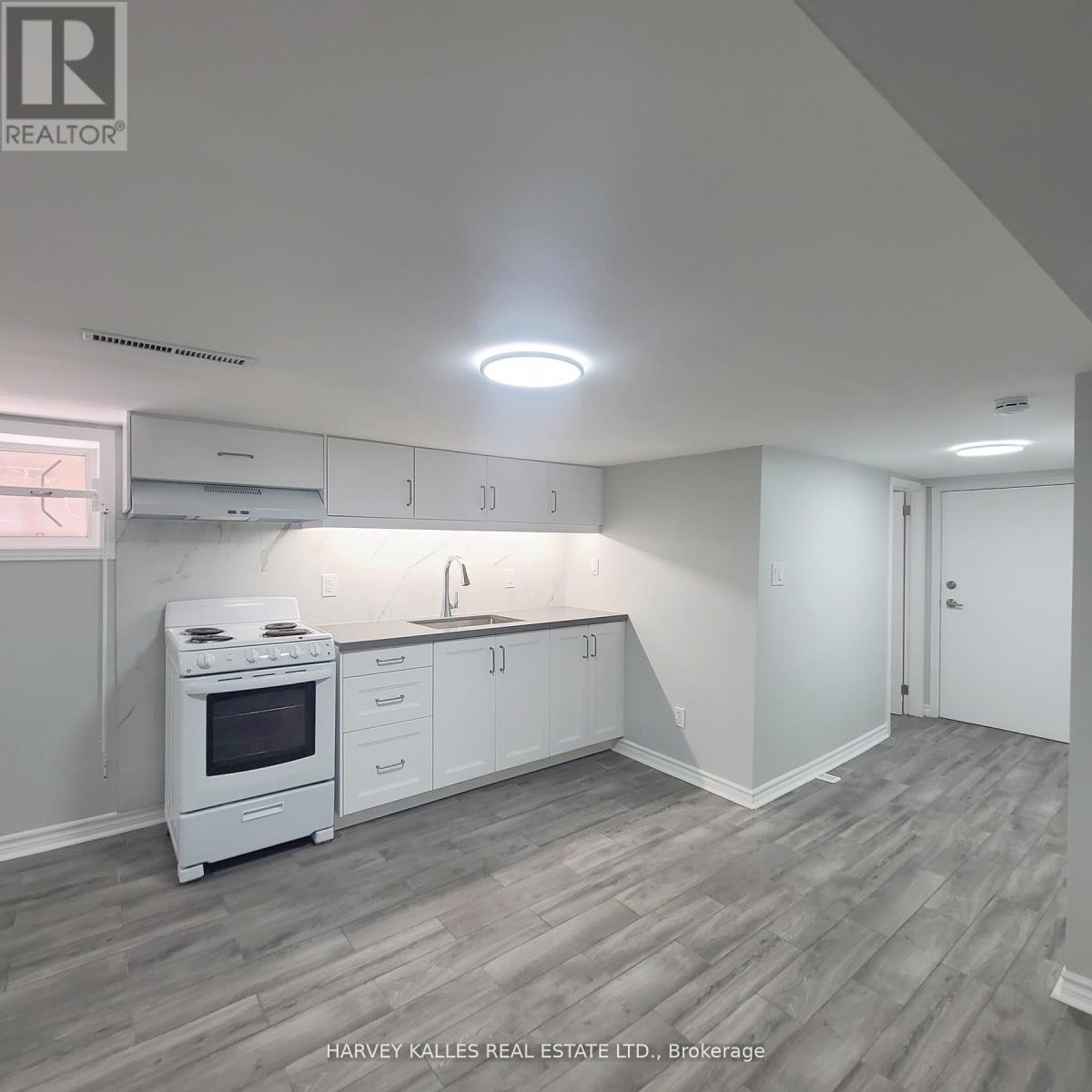 A kitchen with white cabinets and a stove top oven.