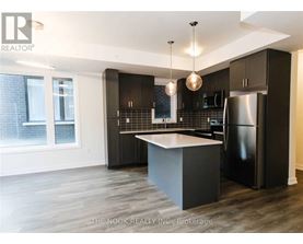 A modern kitchen with dark wood cabinets and a black refrigerator.