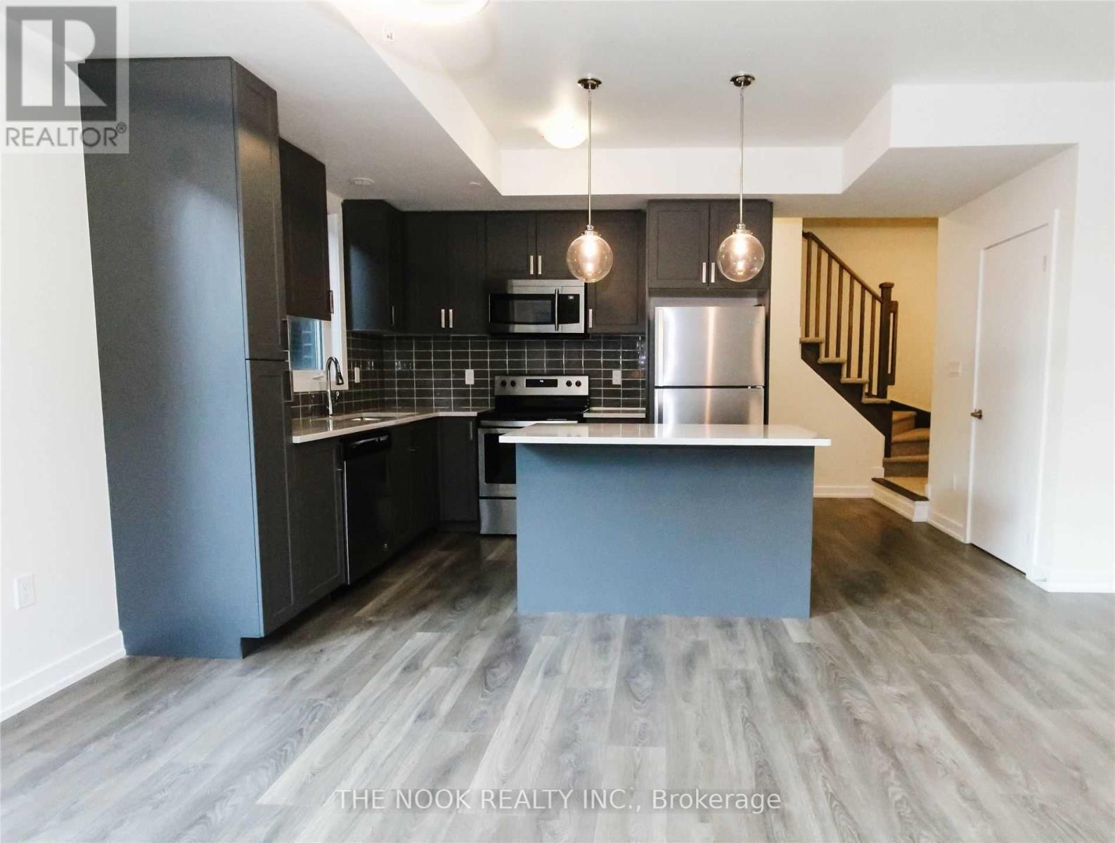 A modern kitchen with a large island and stainless steel appliances.