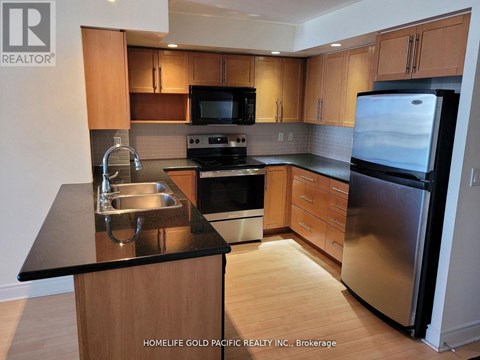A kitchen with wooden cabinets and a black countertop.