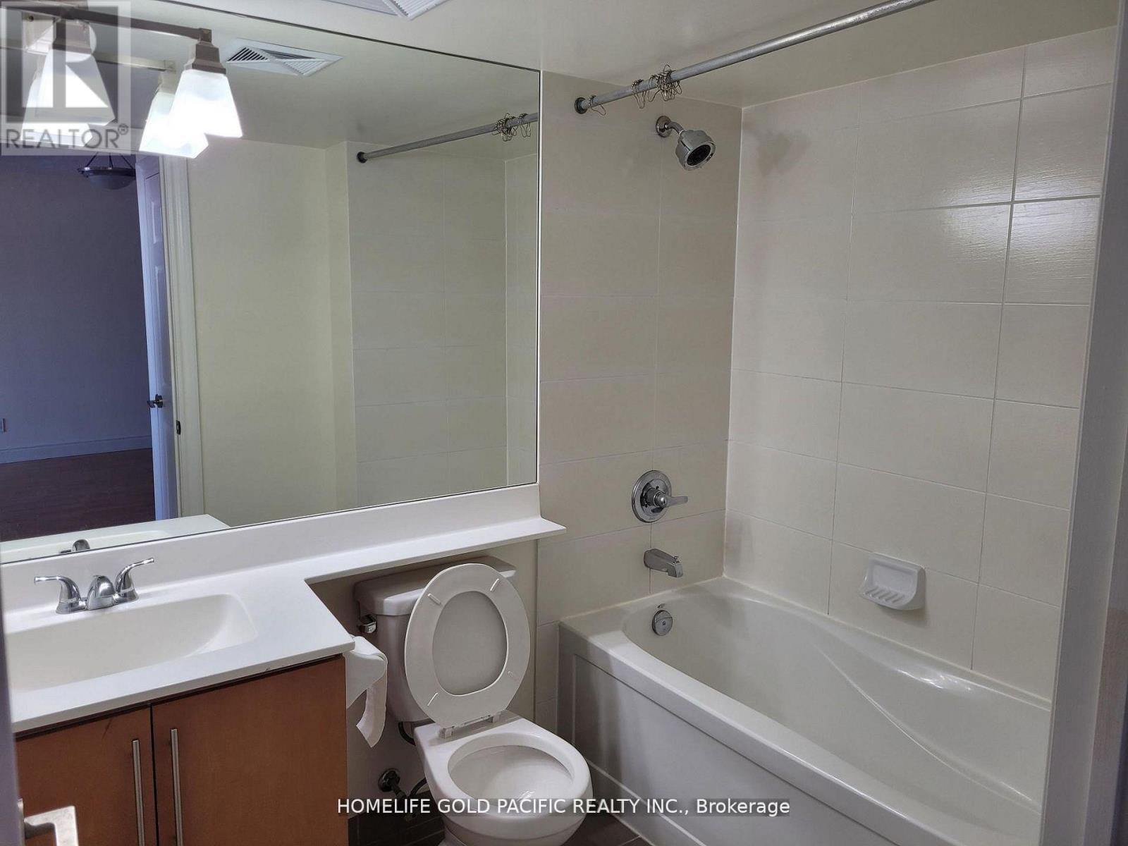 A bathroom with a toilet, sink, and bathtub.