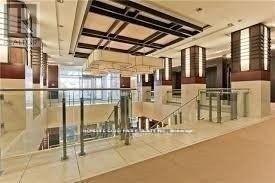 A spacious atrium with a glass floor and a staircase.