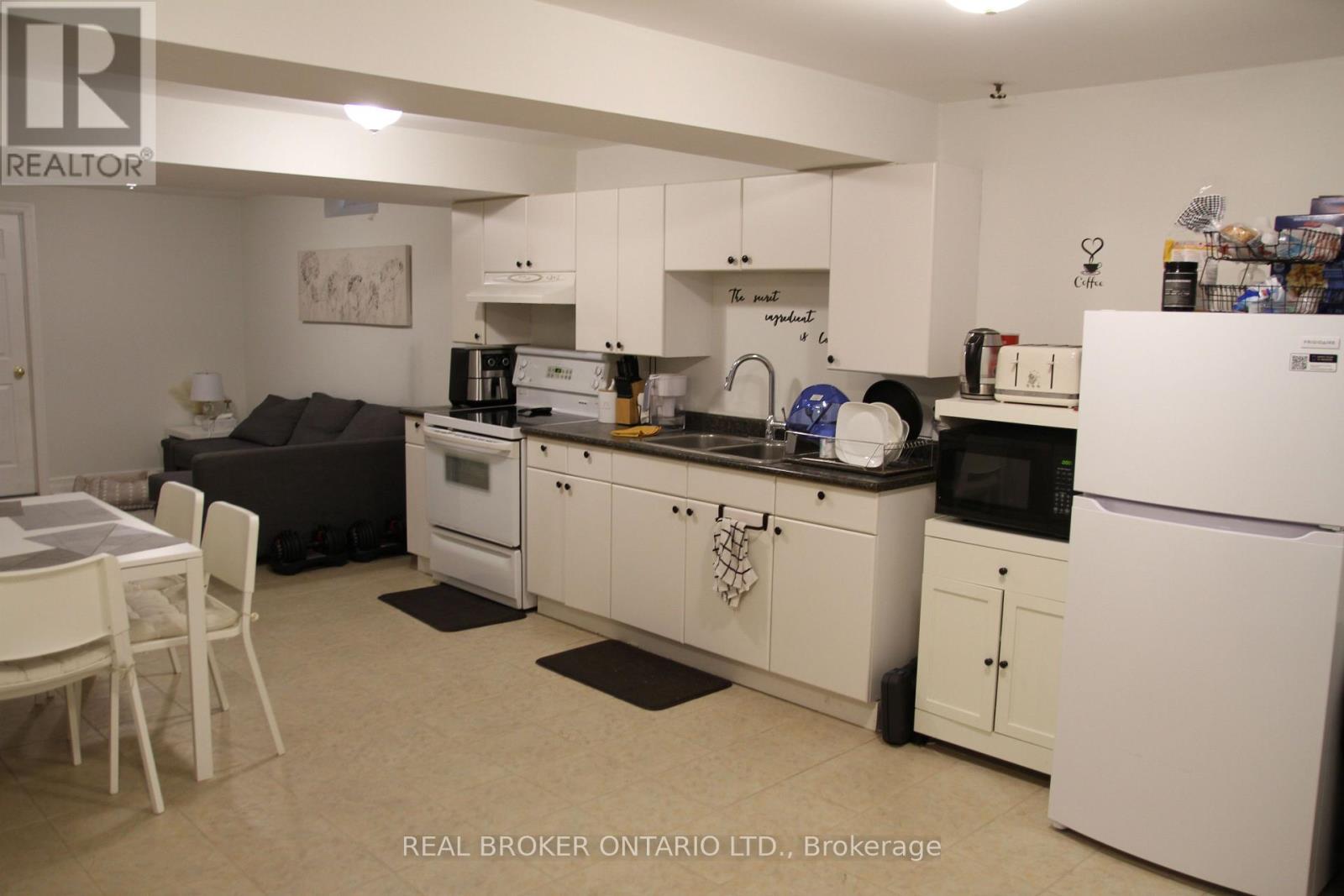 A kitchen with white appliances and cabinets.