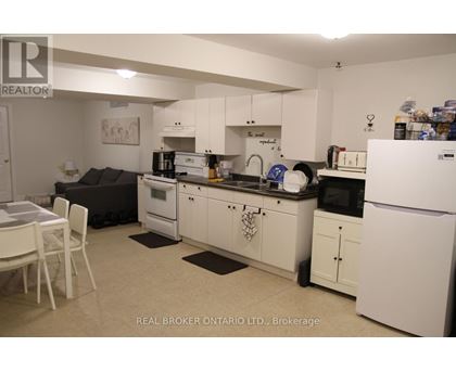 A kitchen with white appliances and cabinets.