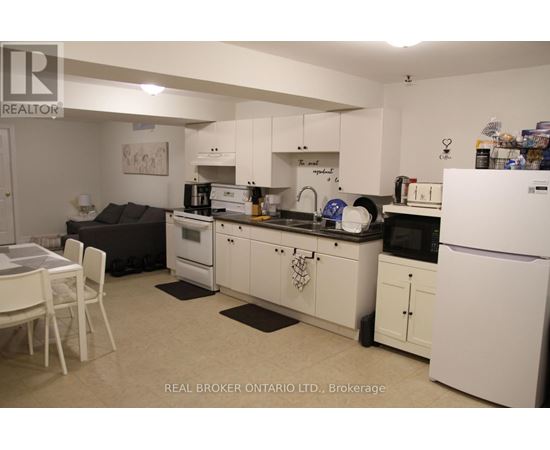 A kitchen with white appliances and cabinets.