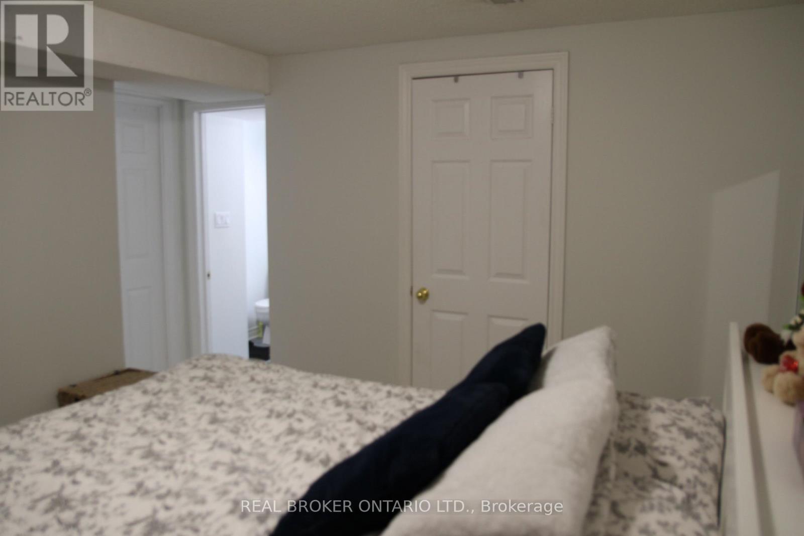 A bedroom with a bed, a door, and a window.