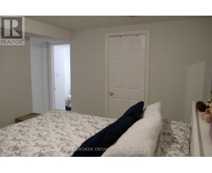 A bedroom with a bed, a door, and a window.