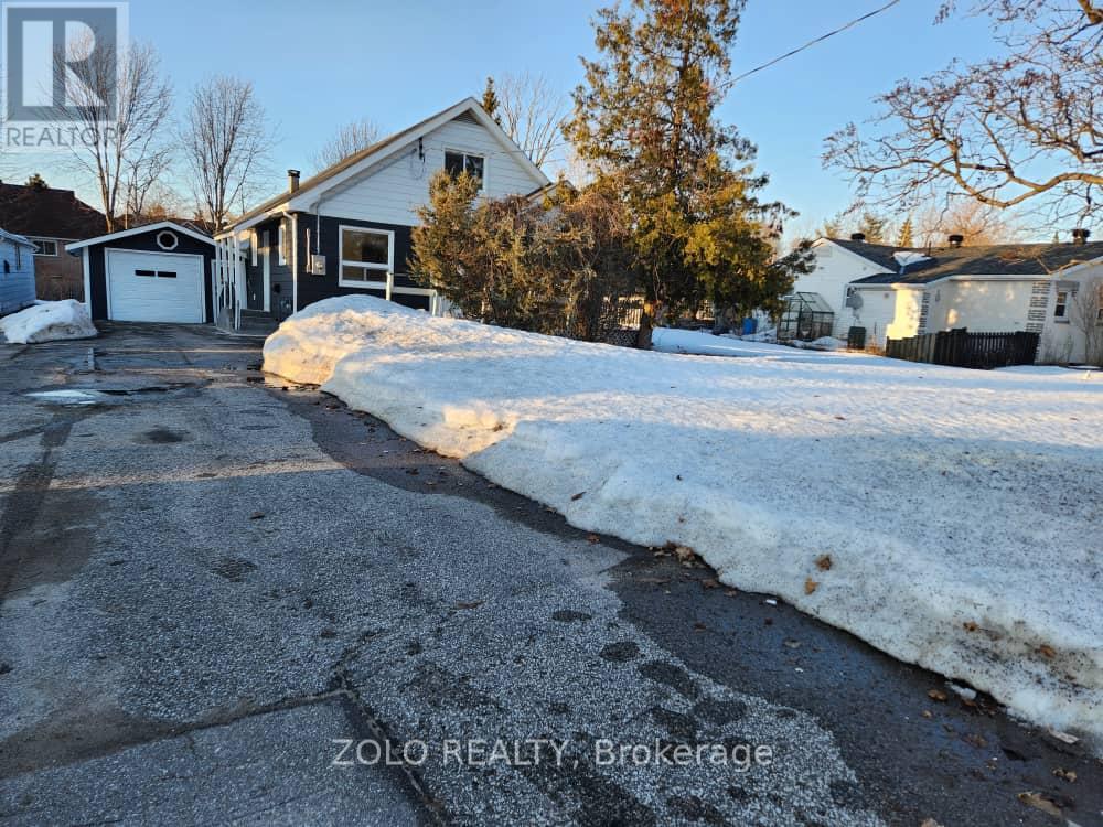 A house with a snow-covered driveway in front of it.