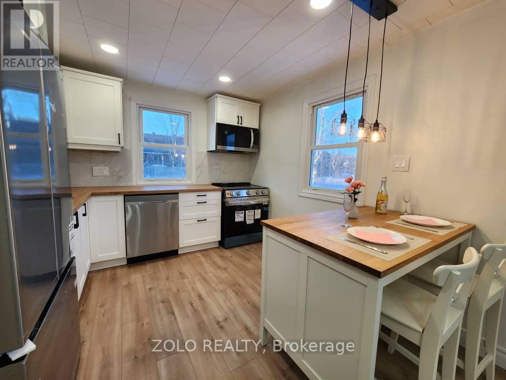 A kitchen with a table and chairs in front of a window.