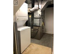 A large industrial machine is in a room with a beige mat on the floor.
