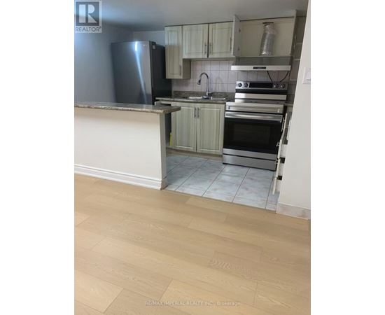 A kitchen with a refrigerator, oven, and sink.