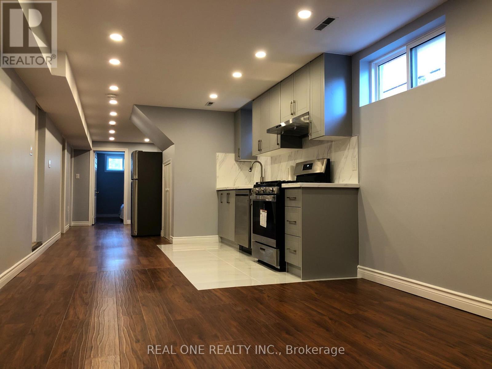 A well-lit kitchen with wooden floors and modern appliances.