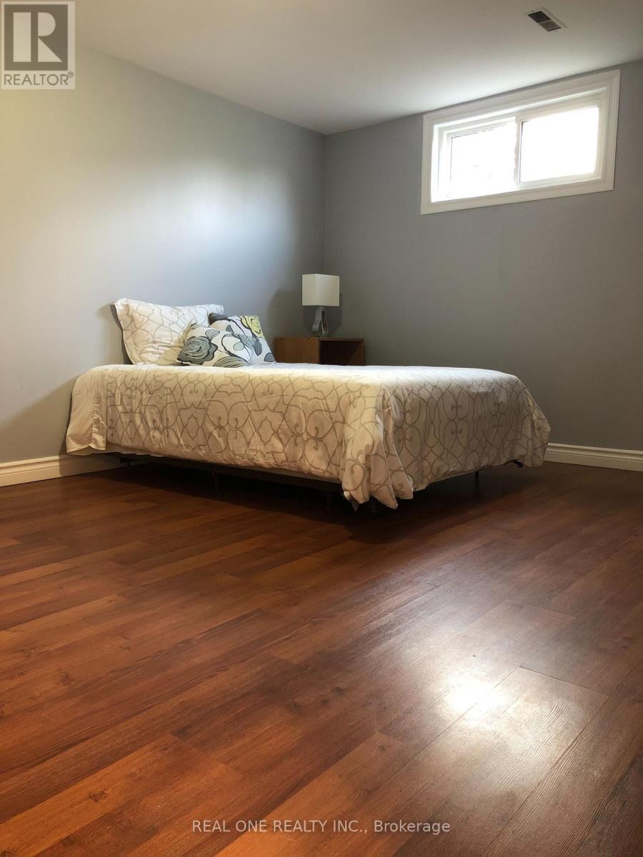A bedroom with a bed, pillows, and a lamp.