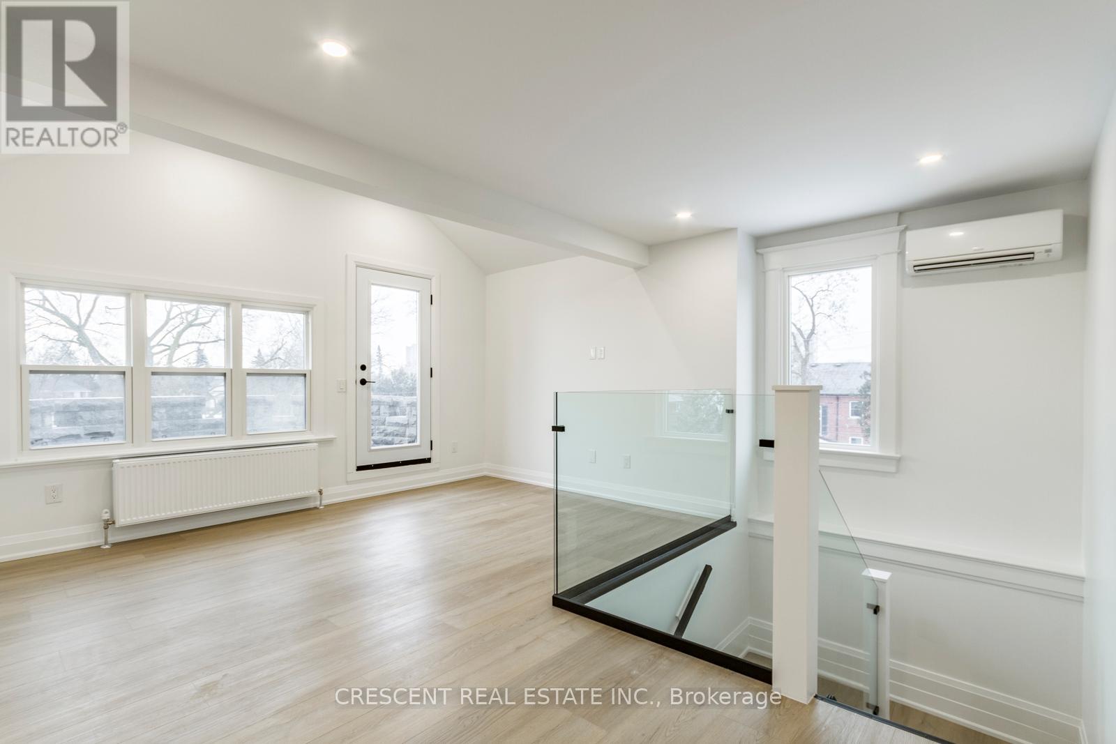 A spacious room with a glass partition wall and a window overlooking a snowy landscape.