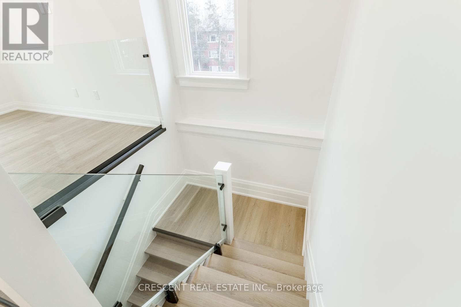 A staircase with a glass railing and wooden steps.