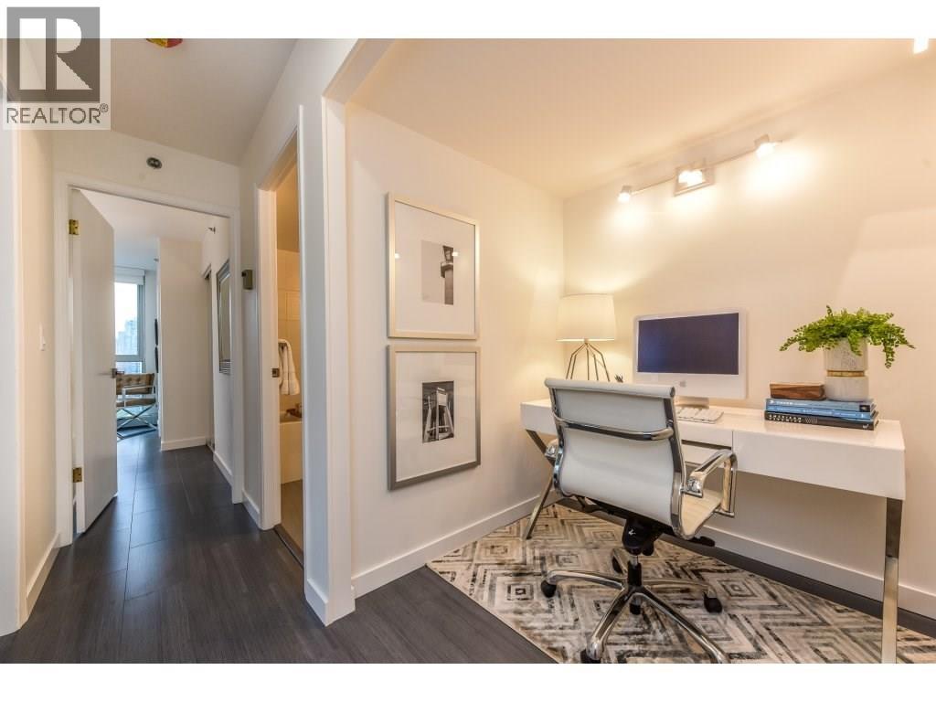 A well-lit office space with a desk, chair, and framed pictures on the wall.