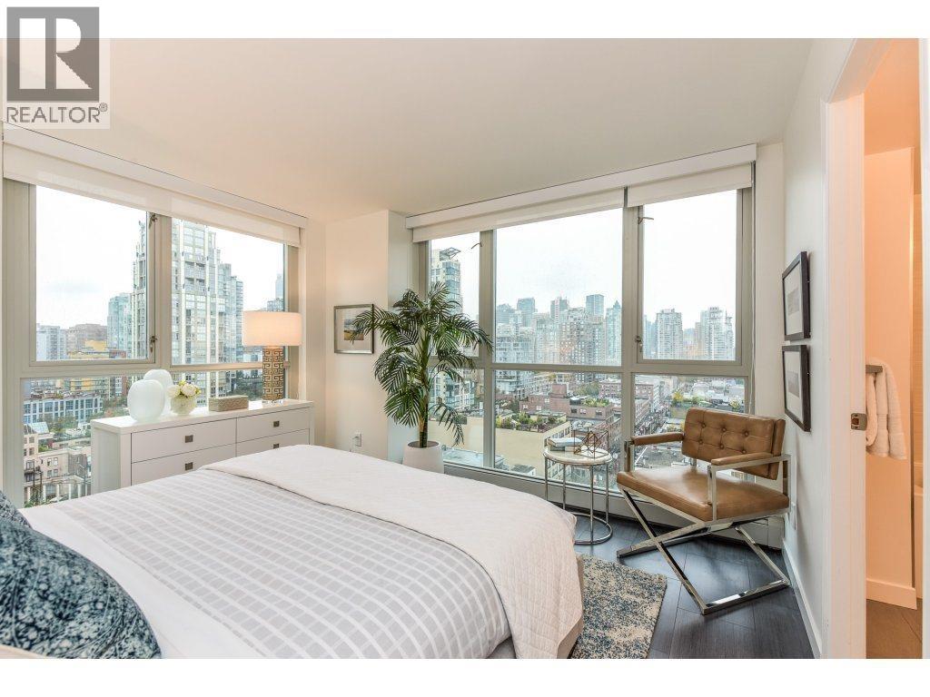 A bedroom with a large bed and a view of the city.