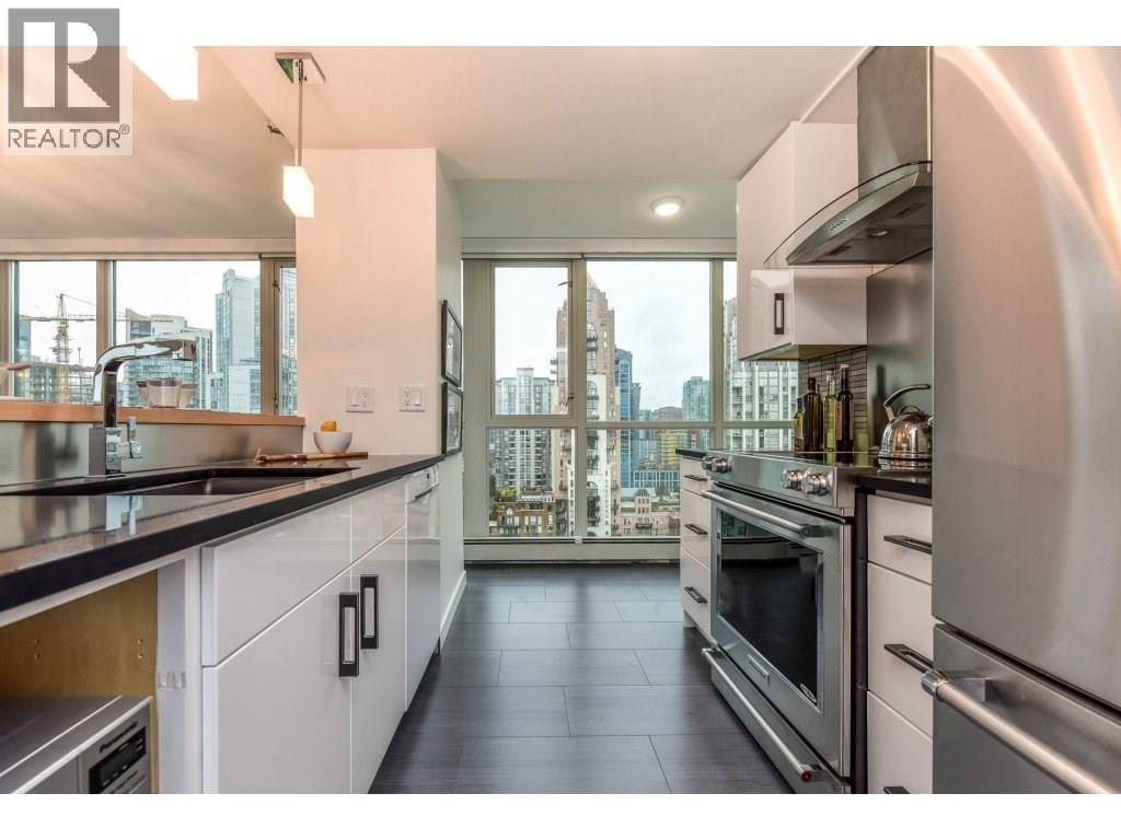 A modern kitchen with stainless steel appliances and a view of the city.