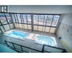 A swimming pool inside a building with a view of the city.