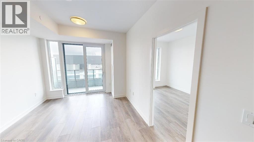A spacious room with a sliding glass door leading to a balcony.
