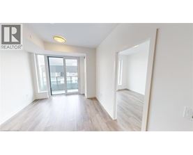 A spacious room with a sliding glass door leading to a balcony.