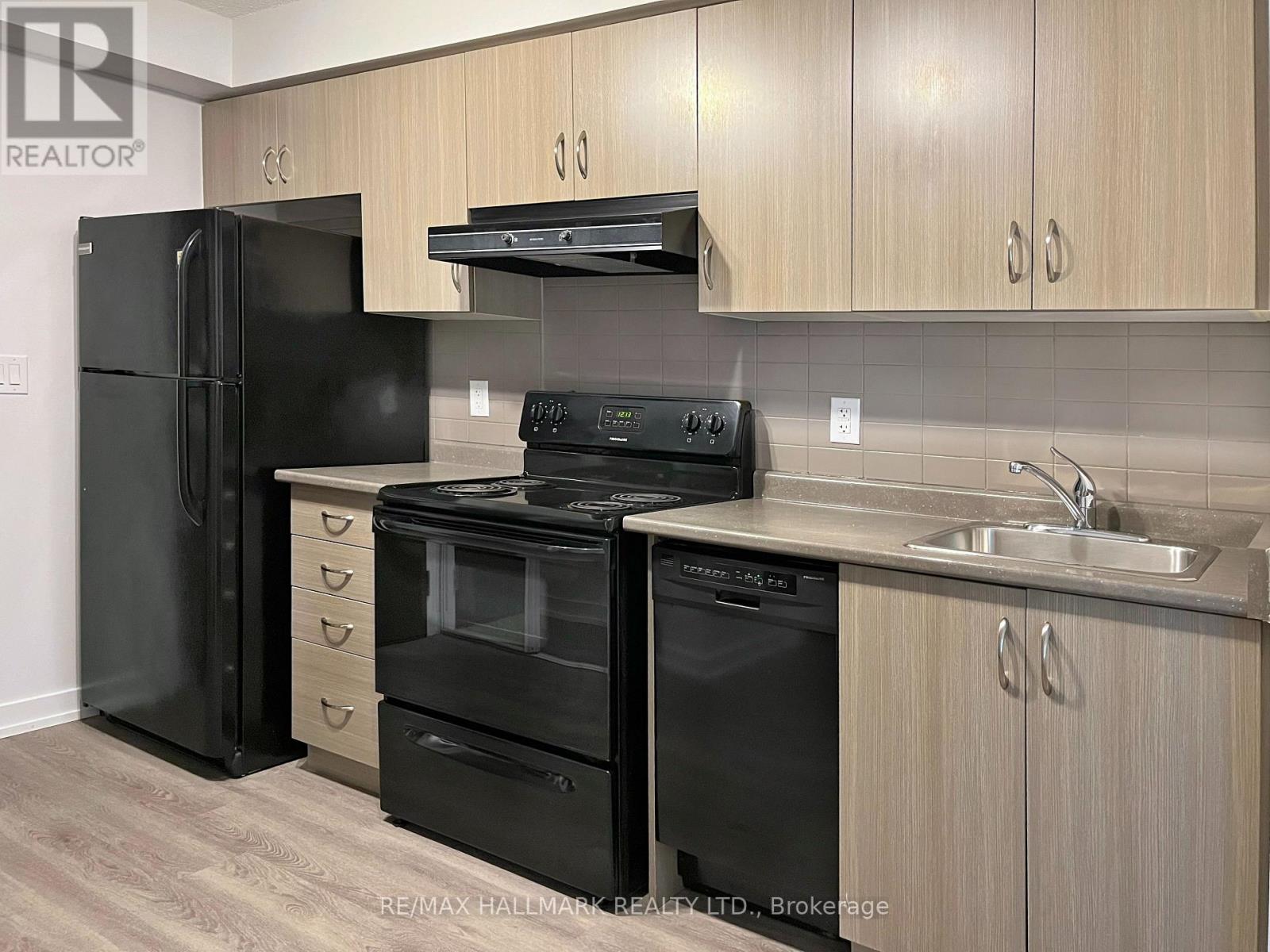 A kitchen with black appliances and wooden cabinets.
