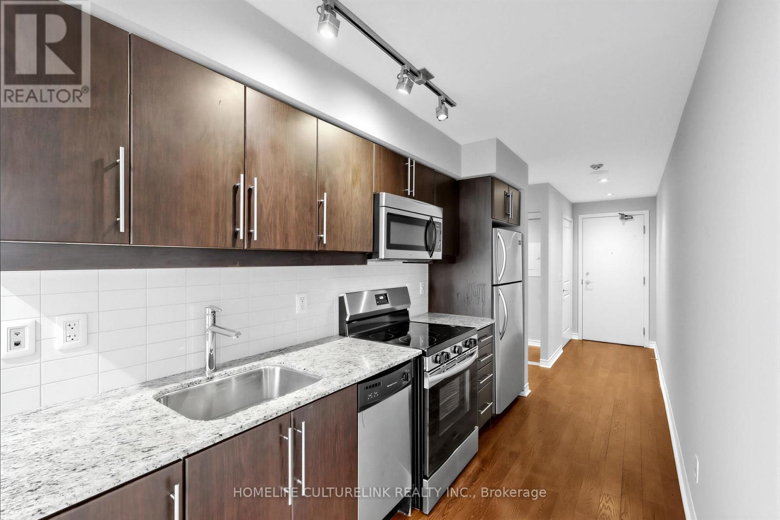 A kitchen with wooden cabinets and stainless steel appliances.
