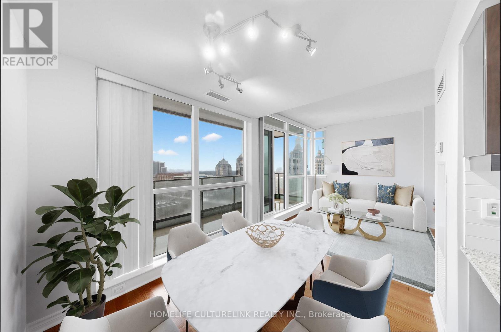 A well-lit dining room with a view of the cityscape outside the large windows.