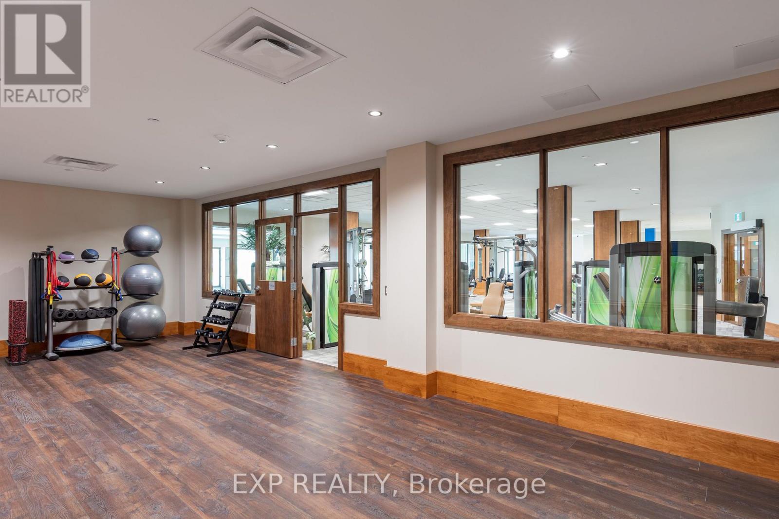 A spacious room with wooden floors and a large mirror on the wall.