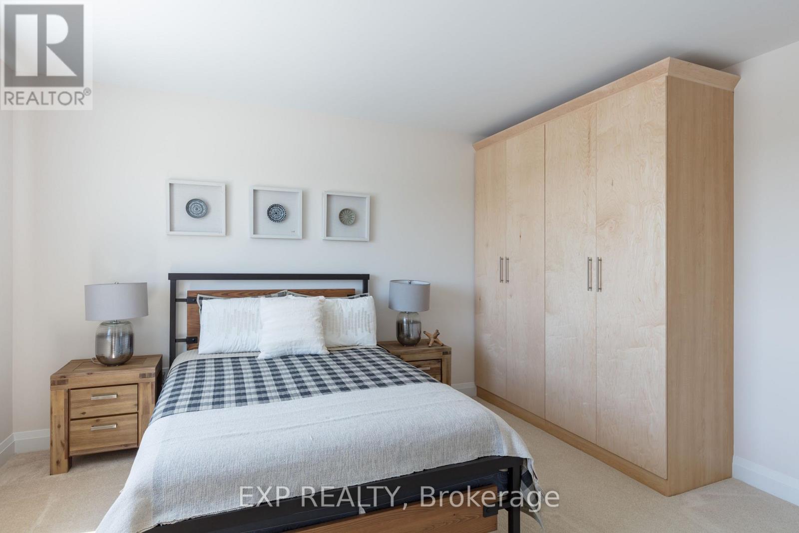 A bedroom with a bed, nightstands, and a wardrobe.