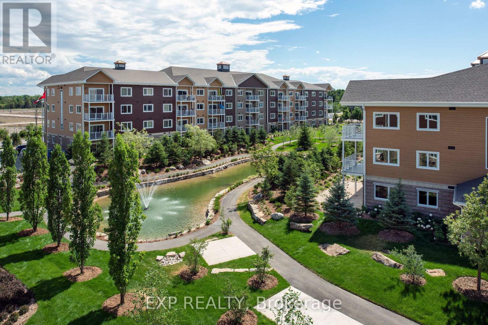 A real estate photo of a building with a pool in the foreground.