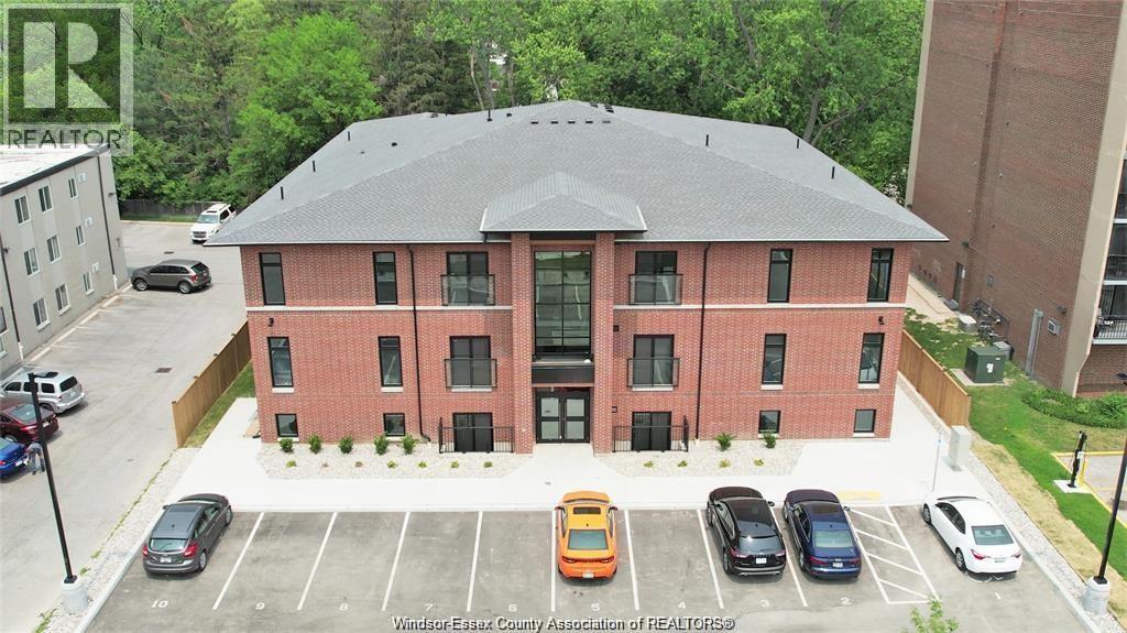 A parking lot with several cars in front of a red brick building.