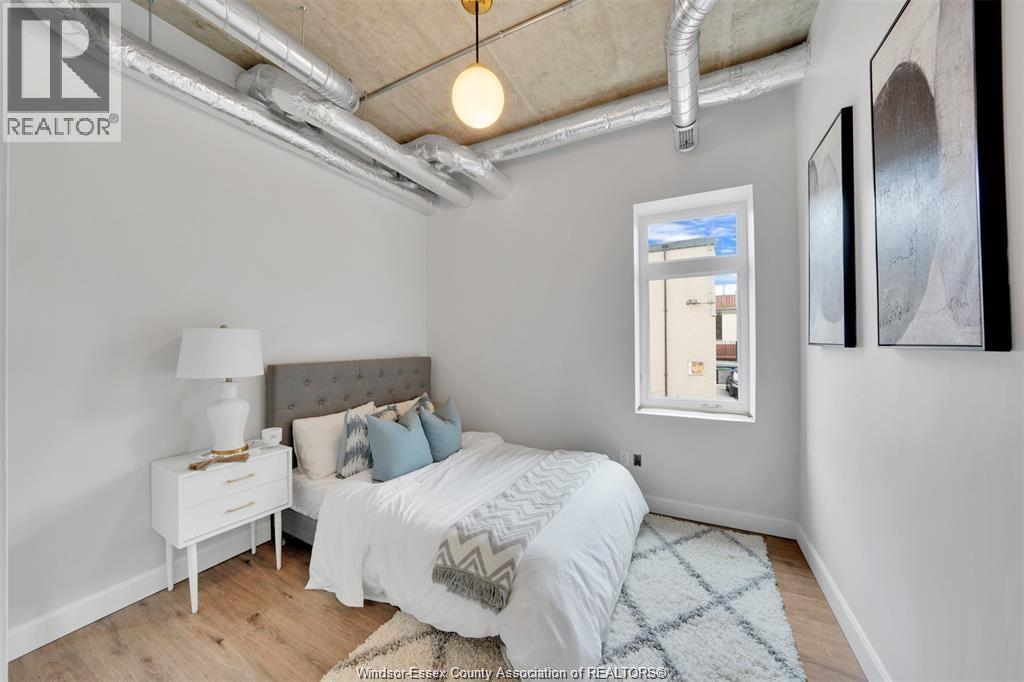 A bedroom with a bed, nightstand, and a window.