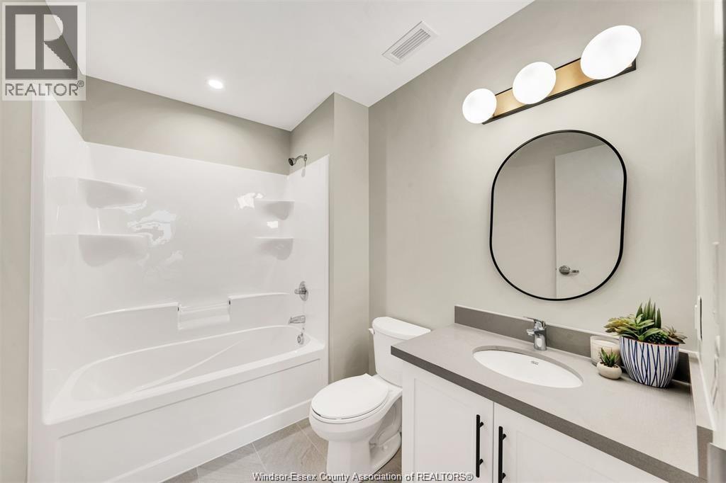 A white bathroom with a toilet, sink, and tub.