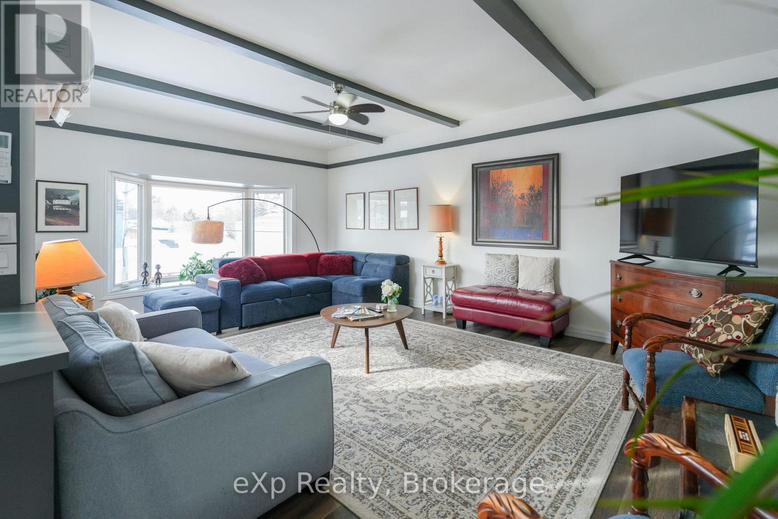 A living room with a grey couch and a red bench.