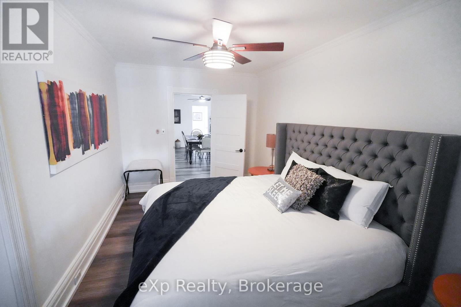 A bedroom with a large bed and a ceiling fan.