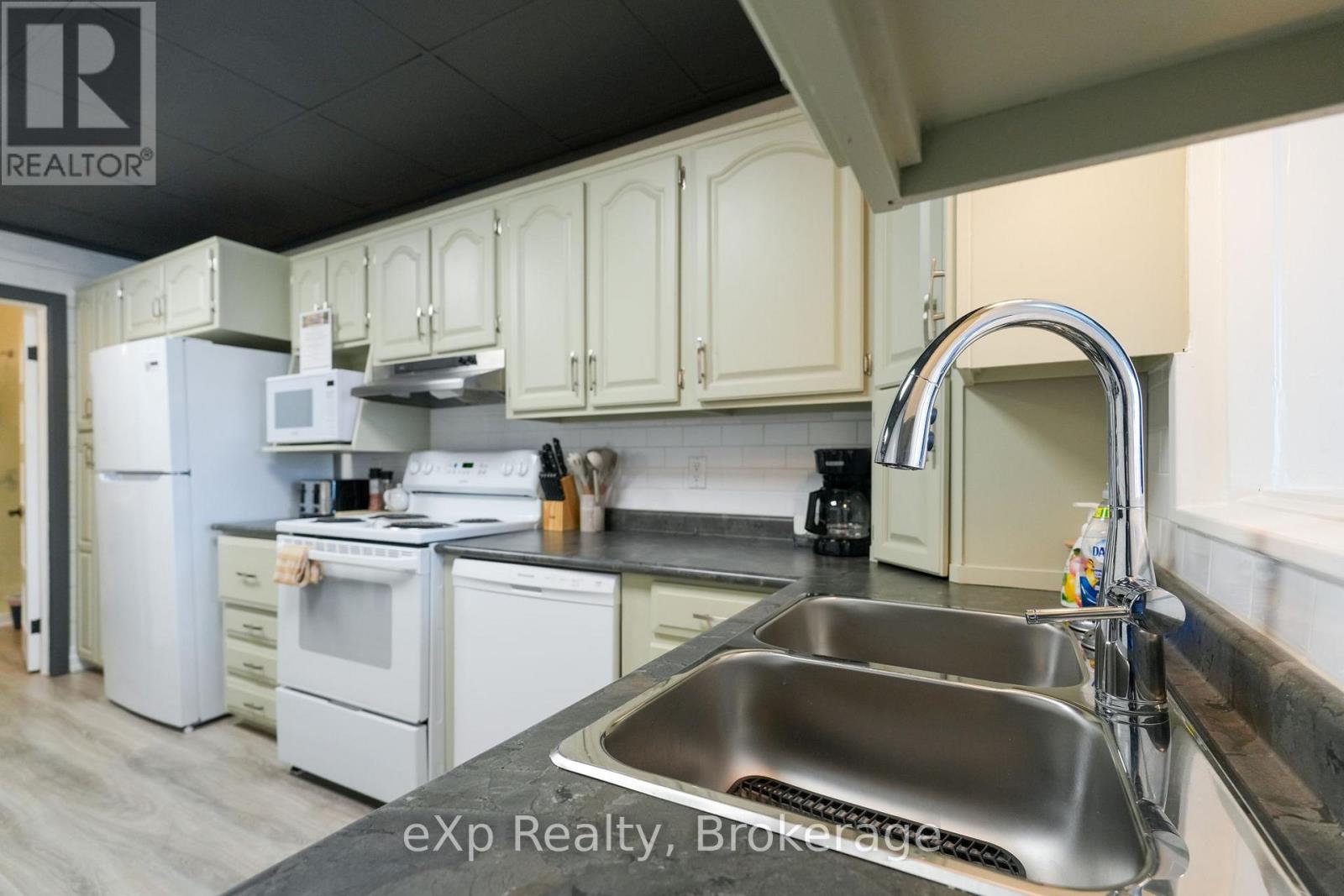 A kitchen with a sink and a refrigerator.
