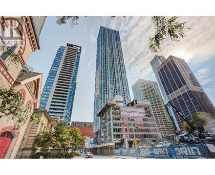 A cityscape with a mix of modern and older buildings, with a clear sky above.