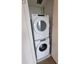 A white Whirlpool washing machine and dryer in a small laundry room.