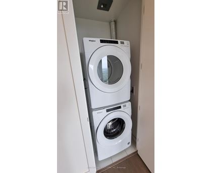A white Whirlpool washing machine and dryer in a small laundry room.