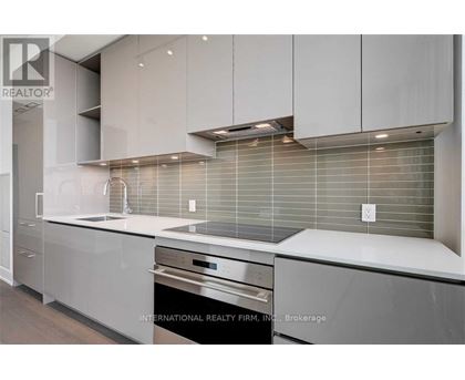 A modern kitchen with stainless steel appliances and white cabinets.