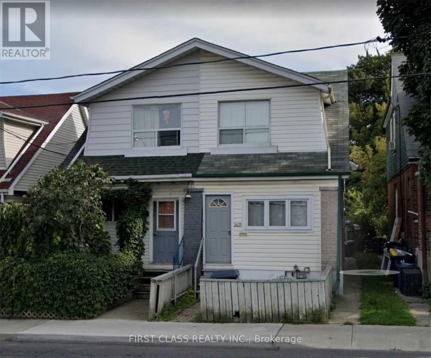 A two-story house with a blue door and a small porch.