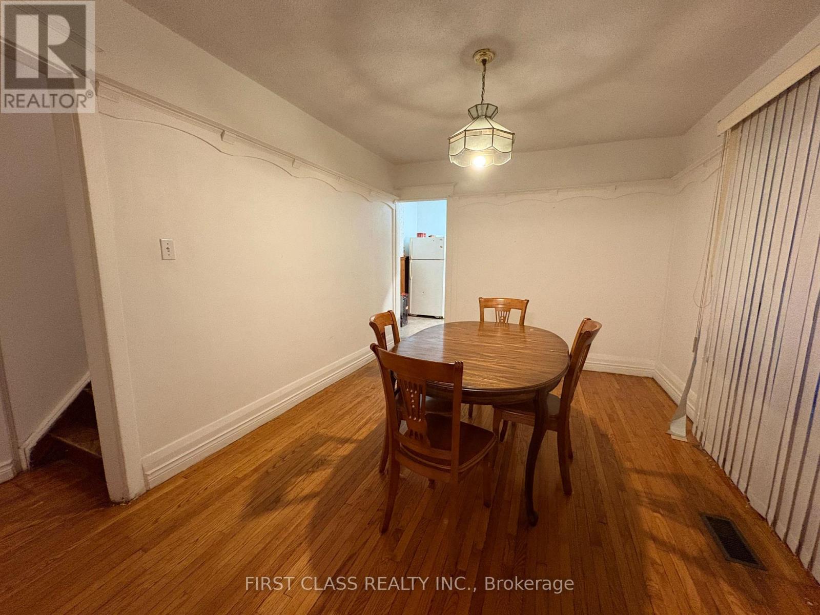 A dining room with a wooden table and chairs.